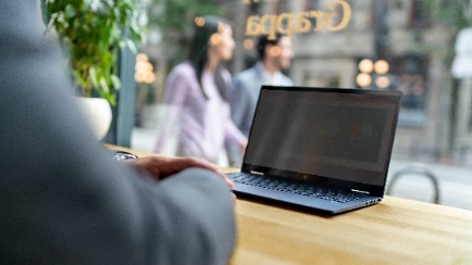 A person sitting at a table using a computer
Description automatically generated
